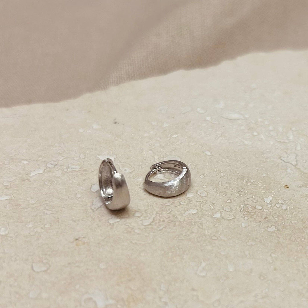 Breite gebürstete Huggie-Creolen Silber